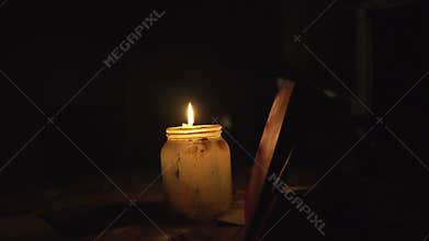 Candle on a table in the bank is lit at night