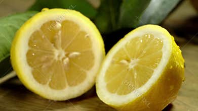 Lemon cut in half under water drops.