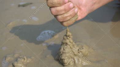 A boy builds a sandcastle