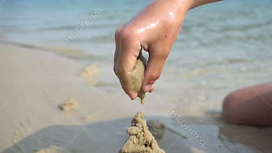 A boy builds a sandcastle
