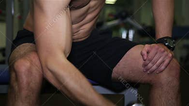 Man builds up muscles lifting a dumbbell in the gym