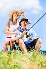 Man with fishing rod angling at lake enjoying hug