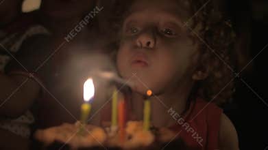 Child blowing candles on birthday cake
