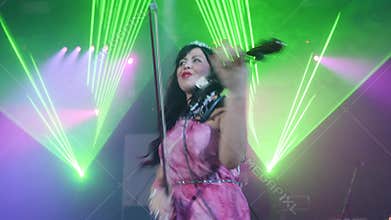 Attractive violinist with crown perform on stage at Halloween party in nightclub