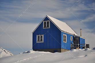 Blue cottage covered by snow, Greenland