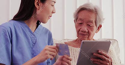 Female asian doctor pharmacist holding medicine pills explaining prescription to older woman patient.