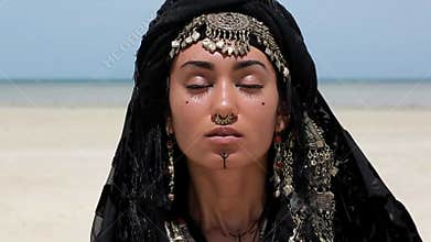 Beautiful young stylish tribal dancer. Woman in oriental costume close up portrait outdoors