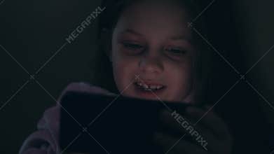 Child insomnia late night fun amused girl phone