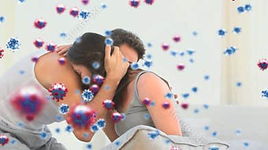 Digital composite video of Covid-19 cells moving against couple embracing each other in background