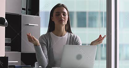 Mindful calm young woman meditate at work with eyes closed