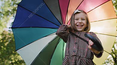 Low angle view of happy girl with colorful umbrella