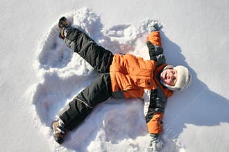 Boy lies on snow