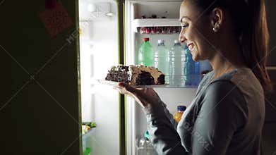 Woman taking a delicious cake for a late night snack