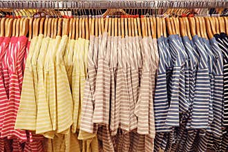Close-up of multi-colored striped t-shirts on hangers