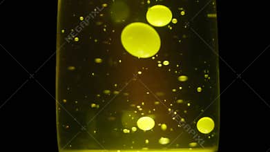 Colorful lava lamp balls moving slowly. Concept. Yellow lava lamp with bubbles and shapes float gently to the top and