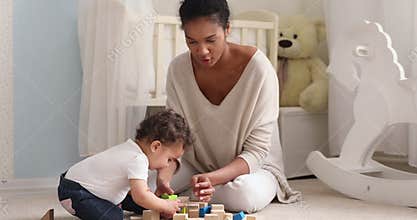 Young african american mother playing with cute toddler kid.