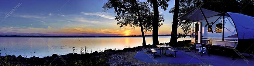 Travel trailer camping by the Mississippi river at sunset in Illinois