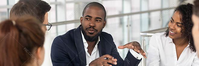 Multi ethnic employees involved in corporate training in boardroom