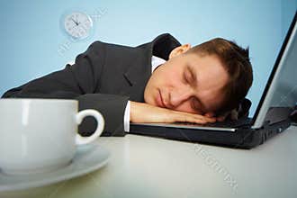 Tired man sleeping on a notebook