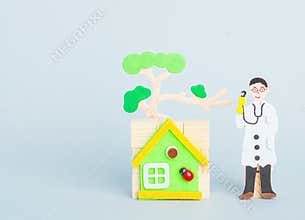 A doctor staying by house with tree. Children`s cartoon doctor.