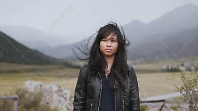 Portrait of young woman in cool cloudy light, gloomy mood and serious face