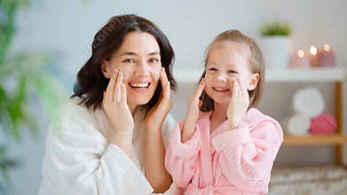 Mother and daughter caring for skin.