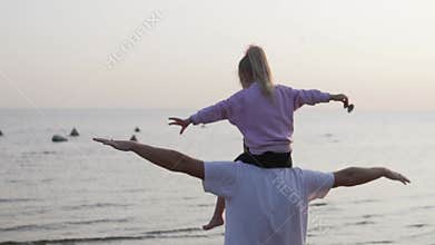 A man and a young daughter admire the Baltic Sea in the autumn during a walk.