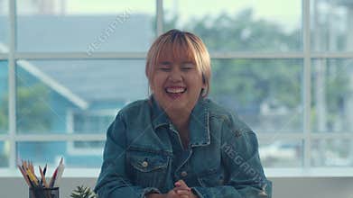 Young Asian creative woman smiling in office. Business female happy relax after work, looking to camera, business situation in