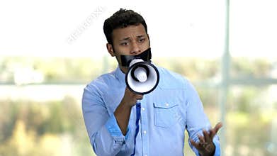 Displeased guy with taped mouth can not speak.