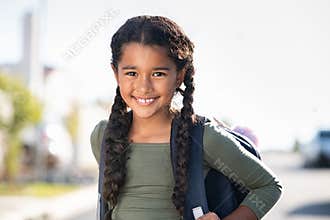 Smiling elementary school girl with bagpack