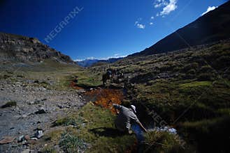 Backpacker in the outdoors filling water