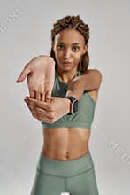 Preparing workout. Vertical shot of a young beautiful mixed race woman in sportswear stretching her arms while standing