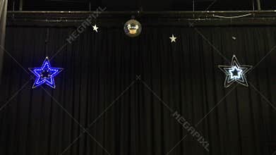 Two flashing stars on stage curtain