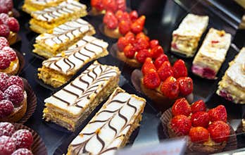 Assortment of french fresh baked sweet pastry with fresh fruits and berries in confectionery shop