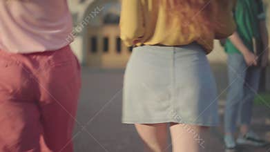 Live camera moves from young female college students strolling on campus to young Caucasian men looking at them and