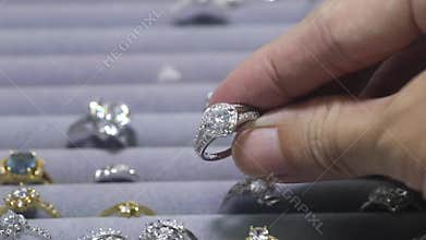 Close-Up Shot Of A Ring With A Diamond In Jewelry Shop Display. A lot of engagement rings with precious stones and camera is