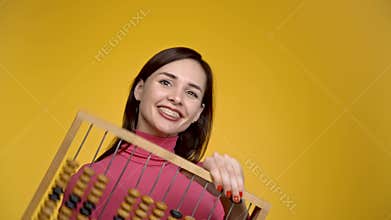 Young attractive girl holds wooden abacus in her hands.
