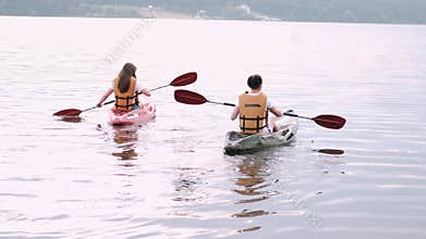 Two women friends kayaking on the lake