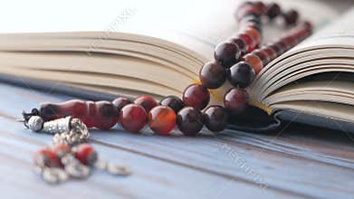 Holy book Quran and rosary on table, close up.