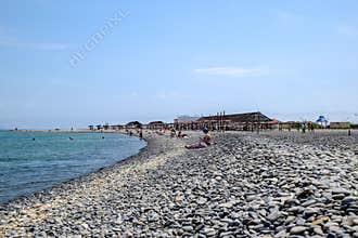 Beach canopies for protection from the sun on the seashore. Pebble beach Aleksino in Novorossiysk