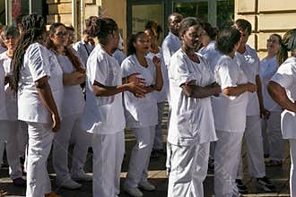 PARIS, FRANCE - JUNE 23, 2017: Group of women from the French Red Cross in a white uniform are standing in a street in the center
