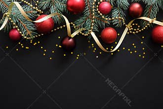 Christmas dark black background with red baubles, Christmas decorations, fir tree branches, confetti star. Xmas frame border, top