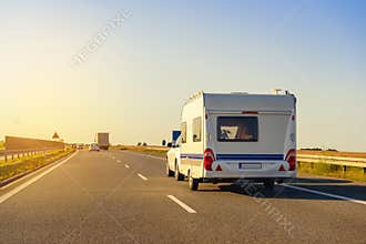 Car with recreational vehicle motor home trailer on highway.
