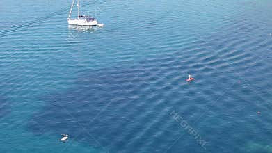 People on a stand up paddle boat over blue sea