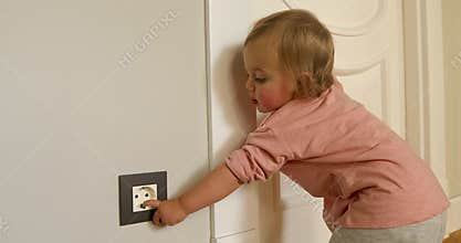Curious child playing with electric plug