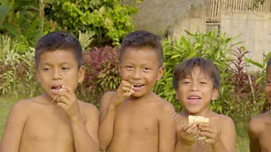 Happy indigenous children are enjoying eating sugarcane