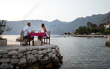 Couple is having a private event dinner on a tropical beach during sunset time