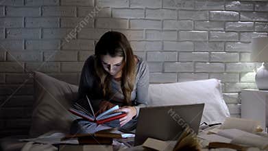 Student reading books late at night, preparing for examination, information
