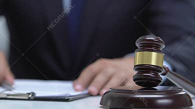 Judge signing up documents and taping wooden gavel, court judgment, justice