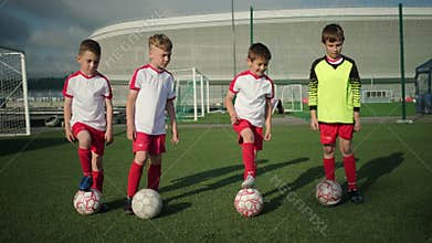 Young guys schoolchildren put balls on soccer field